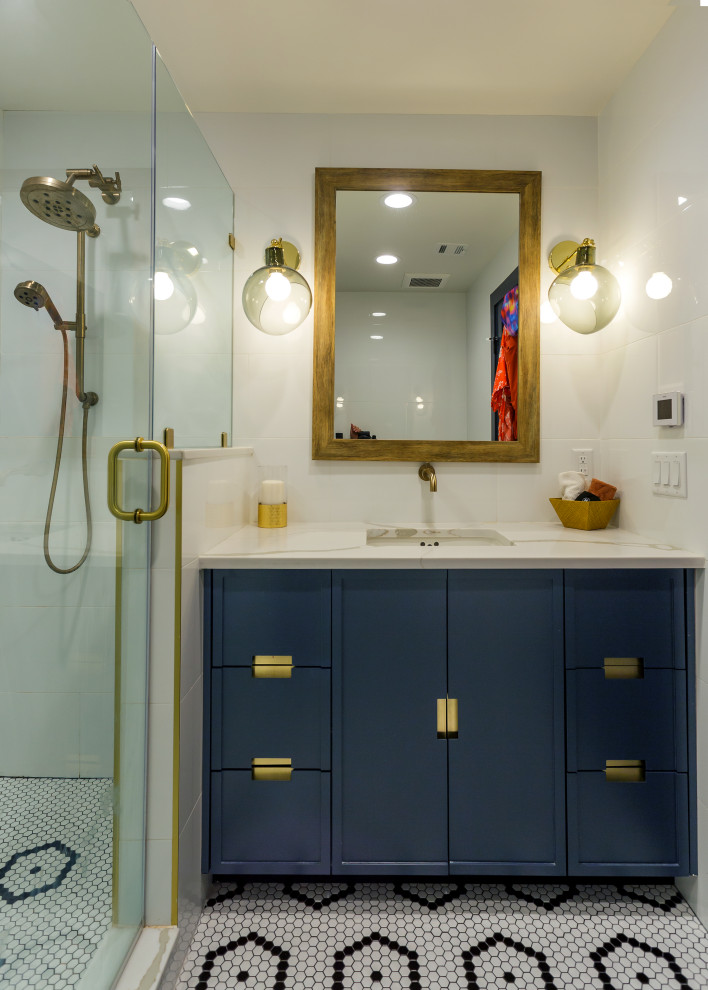 Photo of a small contemporary bathroom in New York with flat-panel cabinets, blue cabinets, an open shower, white tile, subway tile, light hardwood floors, an undermount sink, engineered quartz benchtops, a hinged shower door and white benchtops.