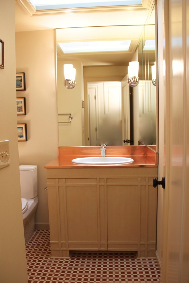 Small eclectic bathroom in Seattle with a drop-in sink, furniture-like cabinets, beige cabinets, copper benchtops, a drop-in tub, a shower/bathtub combo, a two-piece toilet, multi-coloured tile, mosaic tile, beige walls and marble floors.