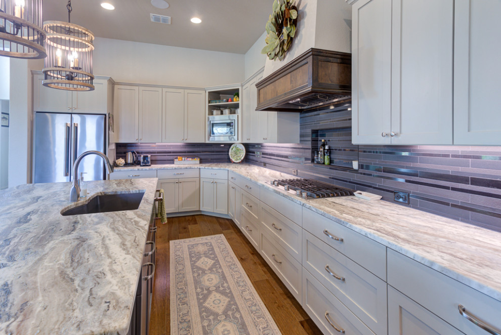 Eat-in kitchen - large transitional galley medium tone wood floor, brown floor and wood ceiling eat-in kitchen idea in Austin with a double-bowl sink, shaker cabinets, white cabinets, granite countertops, black backsplash, porcelain backsplash, stainless steel appliances, an island and gray countertops