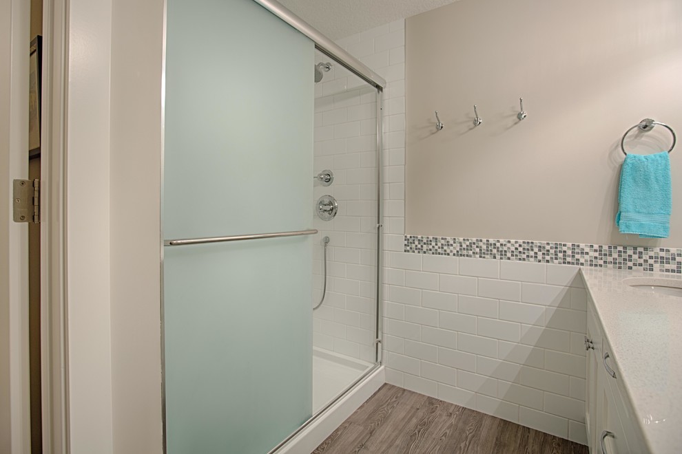 Mid-sized transitional 3/4 white tile and subway tile dark wood floor alcove shower photo in Calgary with white cabinets, white walls, an undermount sink and quartz countertops