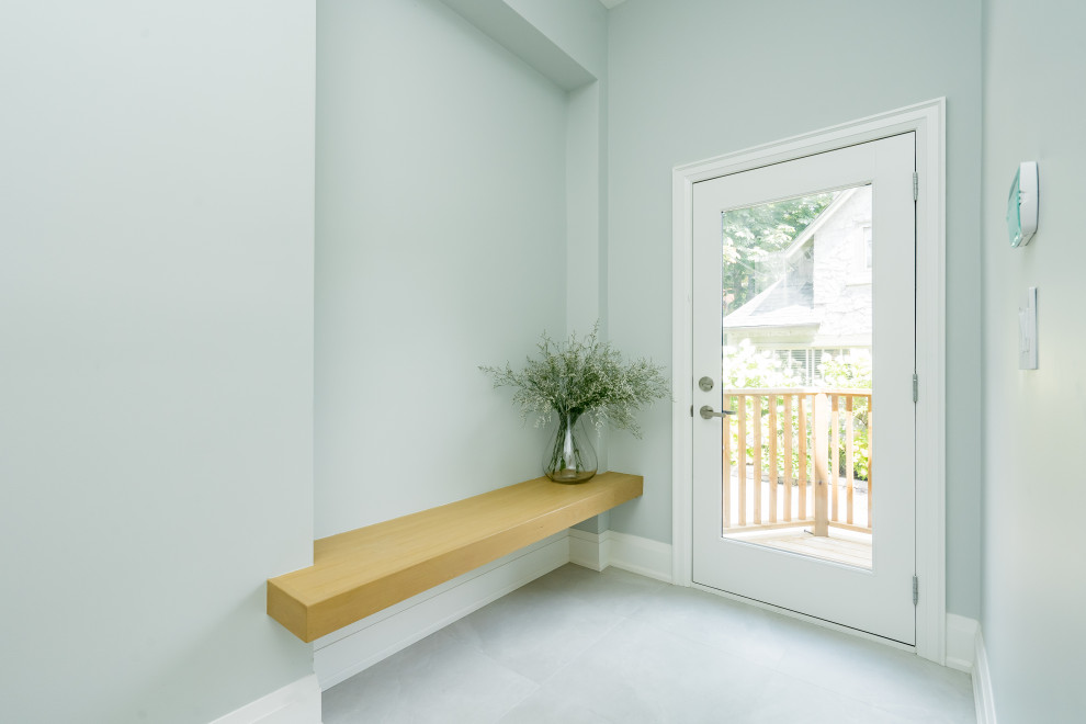 Example of a mid-sized transitional porcelain tile and gray floor entry hall design in Toronto with gray walls and a white front door