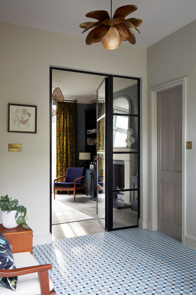 This is an example of a mid-sized modern foyer in London with beige walls, ceramic floors, a single front door and blue floor.