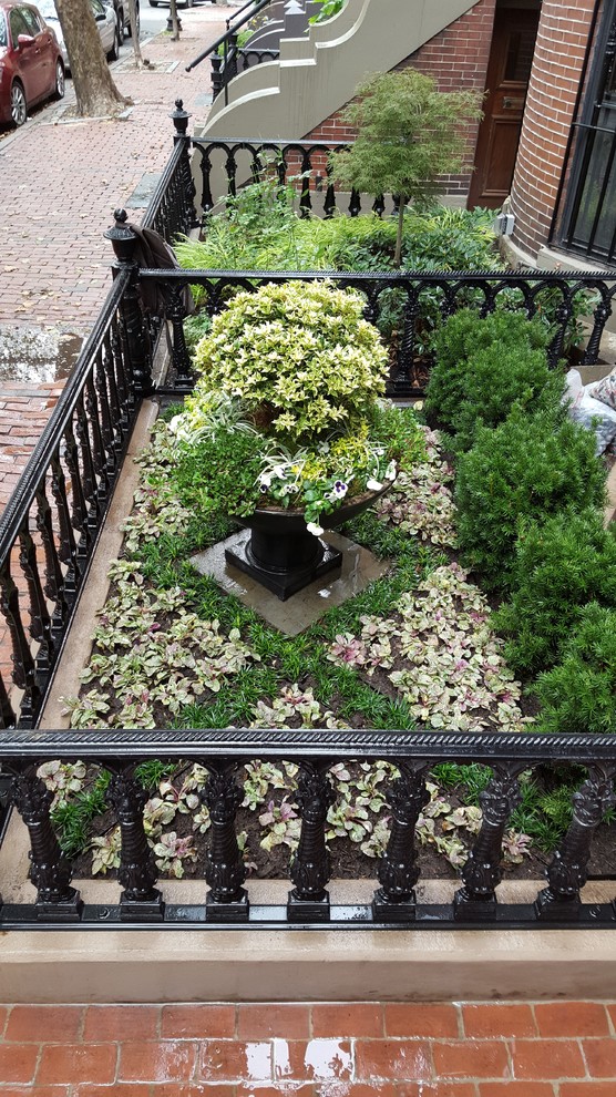 This is an example of a traditional front yard formal garden in Boston with a container garden.