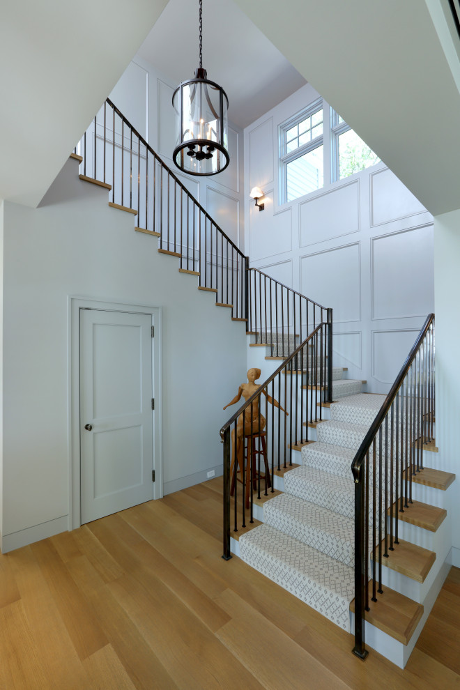 Inspiration for a staircase with metal railing and panelled walls.