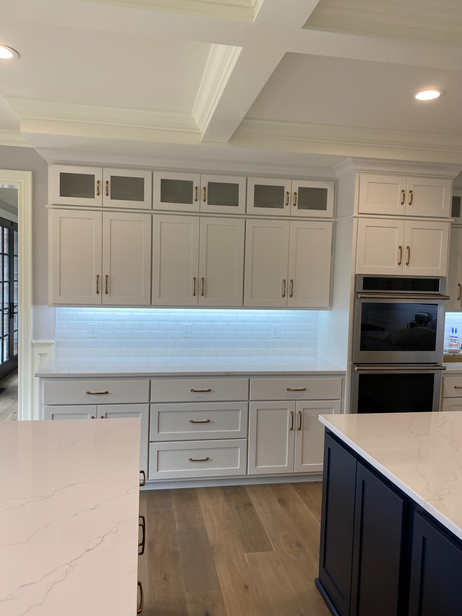 Custom painted kitchen cabinetry with coffered ceiling