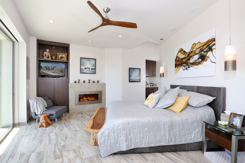 Design ideas for a transitional master bedroom in Orange County with white walls, ceramic floors, a standard fireplace and a stone fireplace surround.