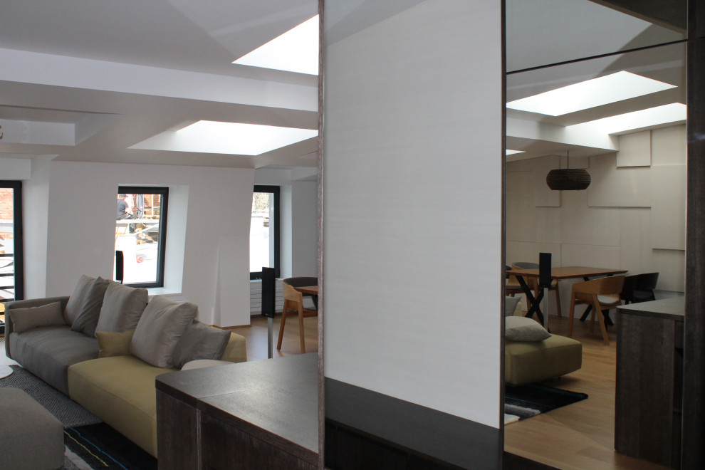 Идея дизайна: большая гостиная комната в современном стиле с белыми стенами, паркетным полом среднего тона, зоной отдыха, бежевым полом, кессонным потолком и панелями на стенах без камина