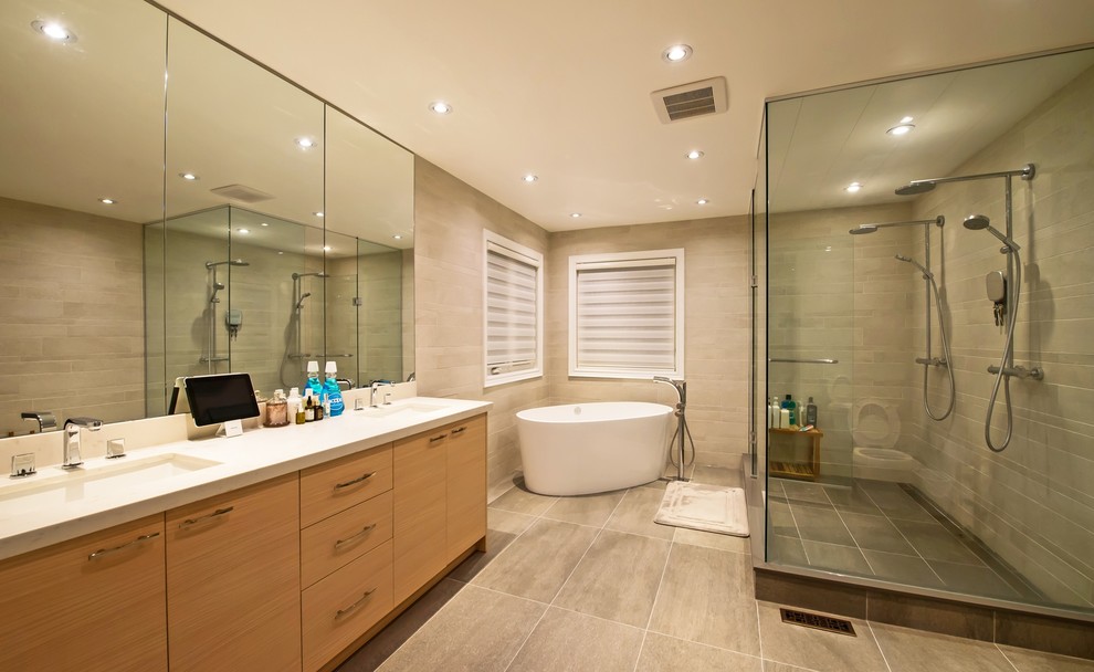 Photo of a contemporary bathroom in Toronto with an undermount sink, flat-panel cabinets, light wood cabinets, engineered quartz benchtops, a one-piece toilet, white tile, porcelain tile and porcelain floors.