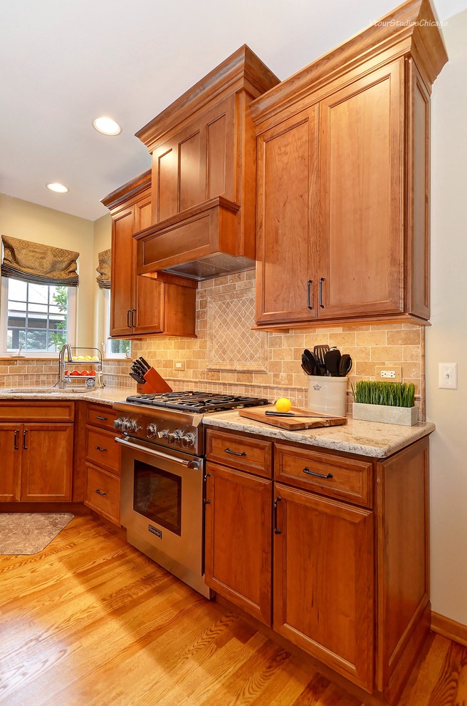 Inspiration for a traditional u-shaped kitchen in Chicago with an undermount sink, flat-panel cabinets, brown cabinets, granite benchtops, brown splashback, stone tile splashback, stainless steel appliances, medium hardwood floors and with island.