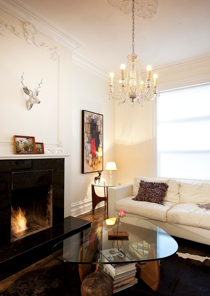 This is an example of a modern living room in Toronto with beige walls, dark hardwood floors and a standard fireplace.