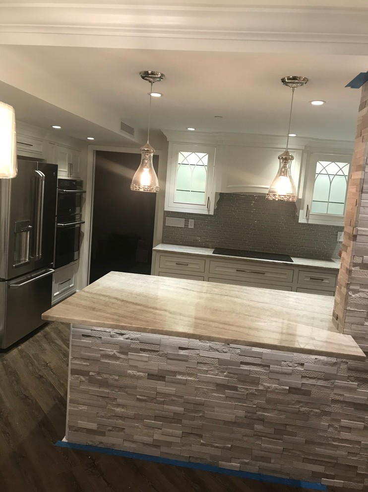 Kitchen - mid-sized transitional medium tone wood floor and brown floor kitchen idea in Miami with recessed-panel cabinets, gray cabinets, gray backsplash, matchstick tile backsplash, paneled appliances and a peninsula