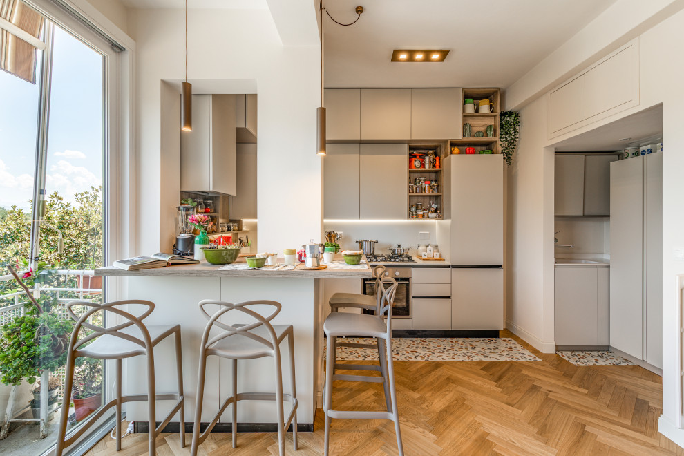 Inspiration for a small modern u-shaped open plan kitchen in Florence with an undermount sink, flat-panel cabinets, white cabinets, quartzite benchtops, engineered quartz splashback, stainless steel appliances, light hardwood floors, with island and brown floor.