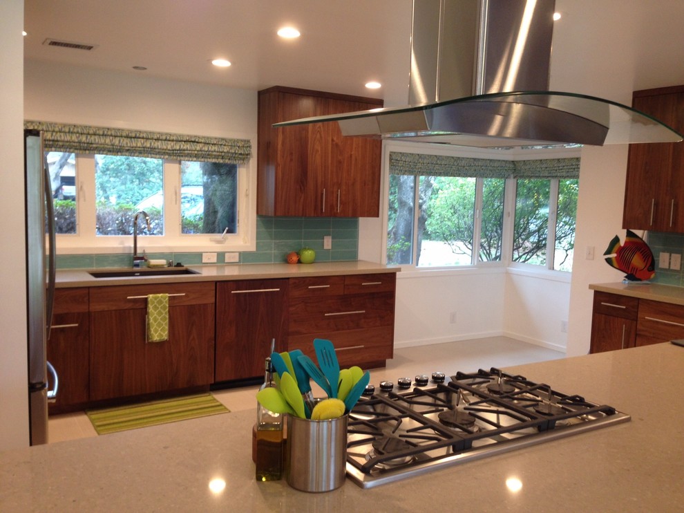 Photo of a mid-sized midcentury u-shaped eat-in kitchen in Other with a single-bowl sink, flat-panel cabinets, medium wood cabinets, quartz benchtops, blue splashback, glass tile splashback, stainless steel appliances, porcelain floors and with island.