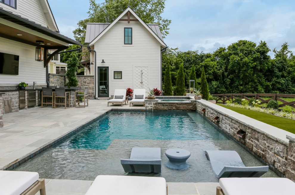 Diseño de piscina campestre de tamaño medio rectangular en patio trasero con privacidad y adoquines de piedra natural