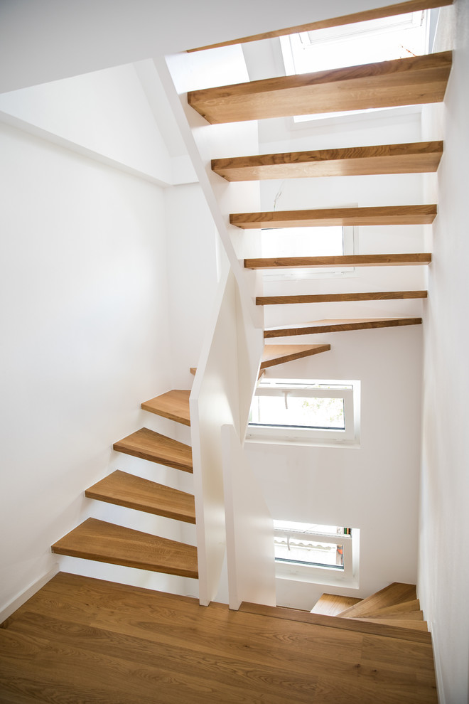 Design ideas for a contemporary wood curved staircase in Stuttgart with wood railing.