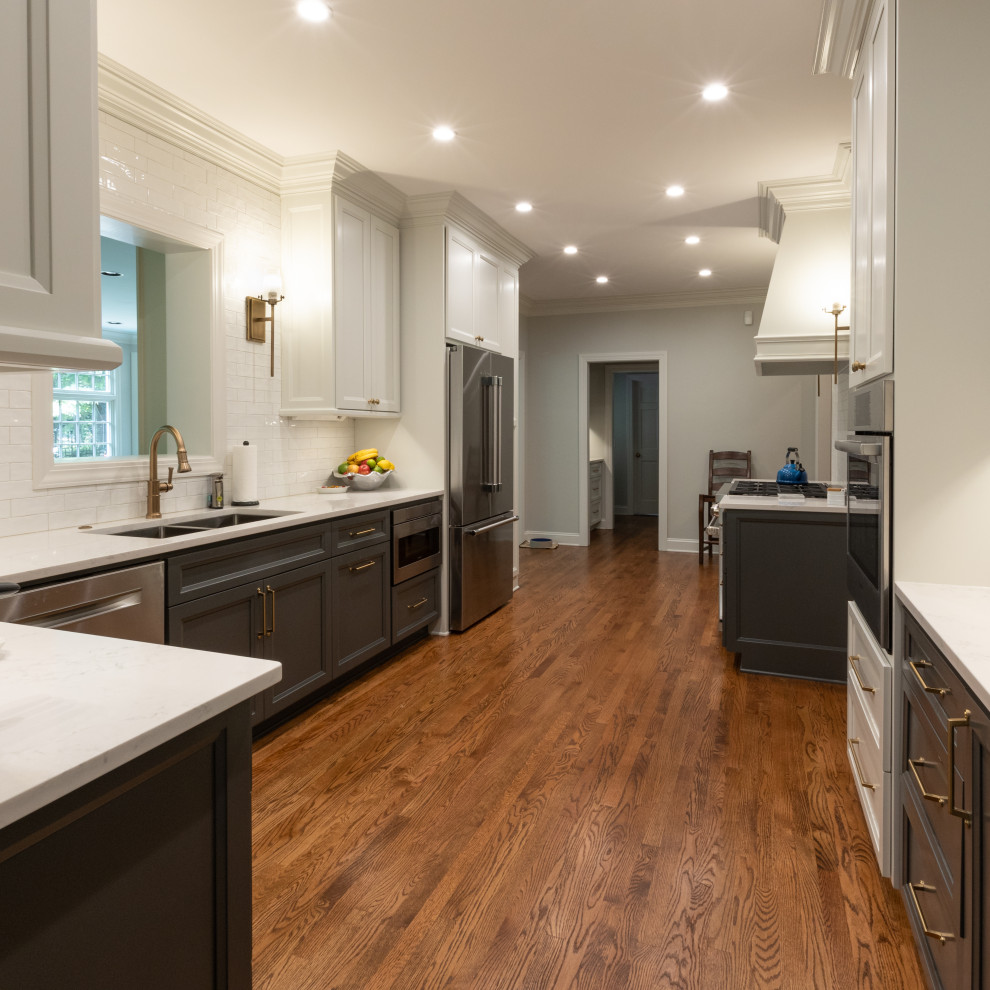 Inspiration for a mid-sized transitional galley medium tone wood floor and brown floor kitchen pantry remodel with an undermount sink, shaker cabinets, gray cabinets, granite countertops, white backsplash, ceramic backsplash, stainless steel appliances, no island and white countertops