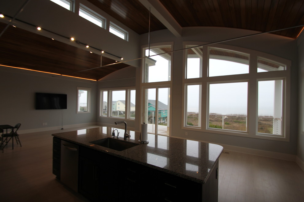 Inspiration for a transitional l-shaped open concept kitchen remodel in Wilmington with an undermount sink, shaker cabinets, dark wood cabinets, granite countertops, brown backsplash and stainless steel appliances