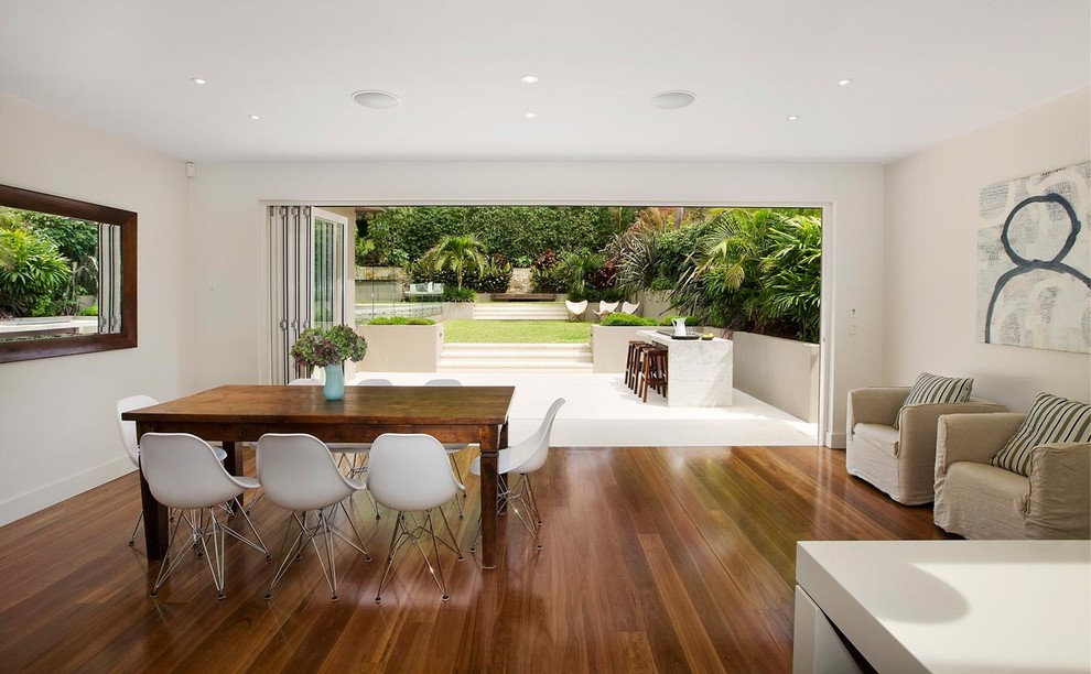 Photo of a contemporary open plan dining in Sydney with white walls and medium hardwood floors.