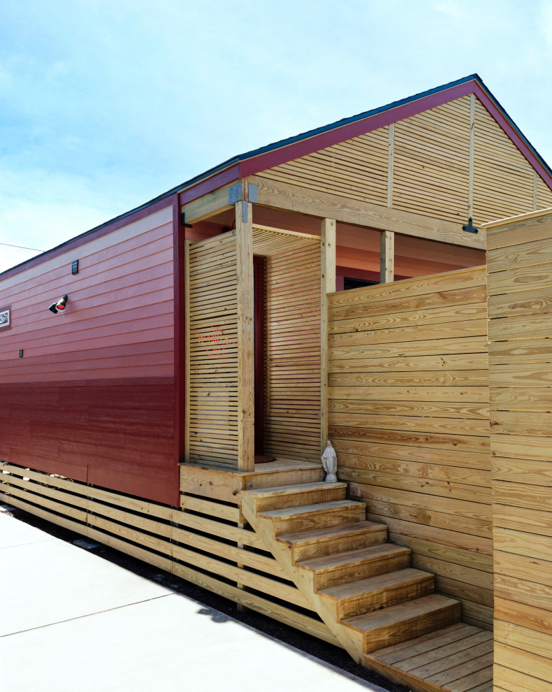 Idées déco pour une petite façade de maison rouge éclectique en panneau de béton fibré de plain-pied avec un toit à deux pans, un toit en shingle et un toit noir.