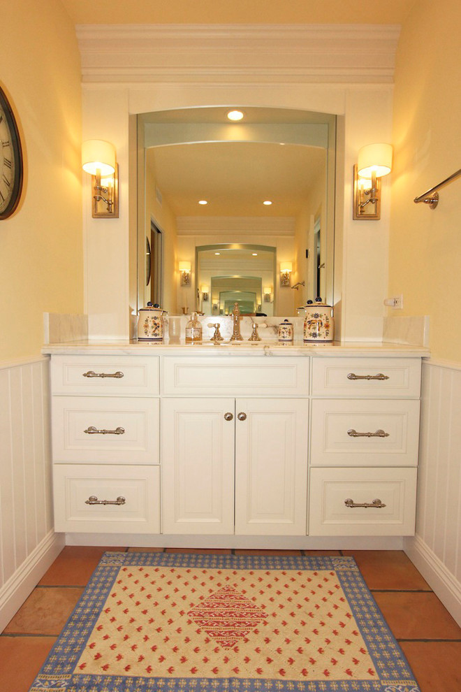 Design ideas for a mid-sized traditional bathroom in San Diego with raised-panel cabinets, white cabinets, a corner shower, yellow walls, terra-cotta floors, an undermount sink, marble benchtops, white tile, ceramic tile and a freestanding tub.