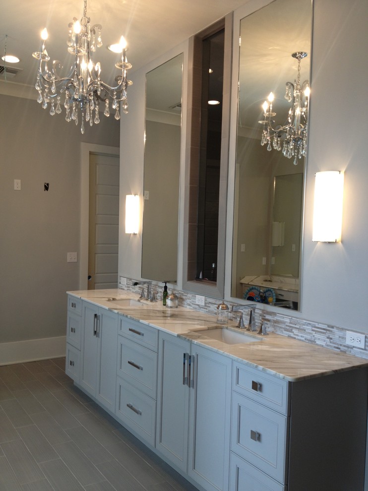 This is an example of a transitional bathroom in New Orleans with an undermount sink, flat-panel cabinets, grey cabinets, marble benchtops and gray tile.