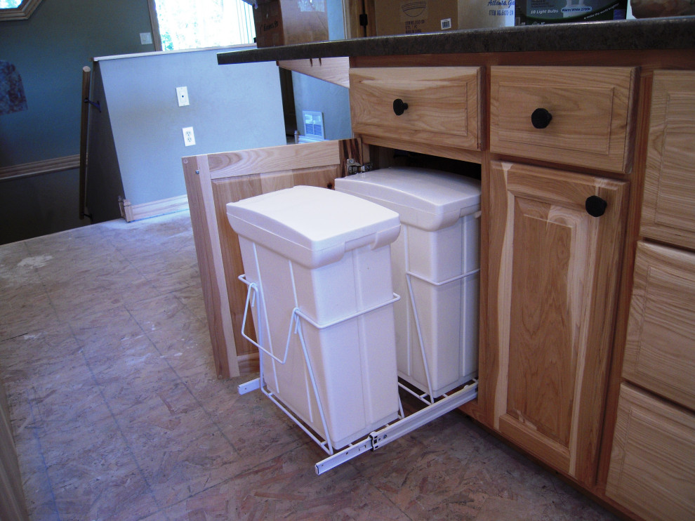 Eat-in kitchen - mid-sized u-shaped laminate floor and brown floor eat-in kitchen idea with a double-bowl sink, raised-panel cabinets, beige cabinets, laminate countertops, black backsplash, stainless steel appliances, an island and black countertops