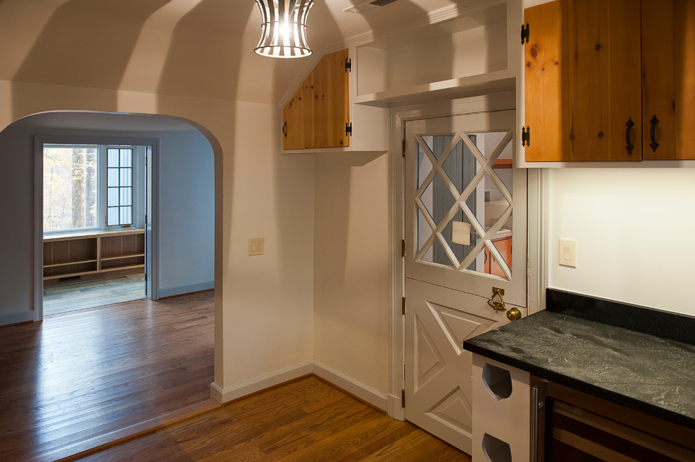 Example of a large mountain style medium tone wood floor kitchen pantry design with an undermount sink, soapstone countertops, stainless steel appliances, no island, flat-panel cabinets and medium tone wood cabinets