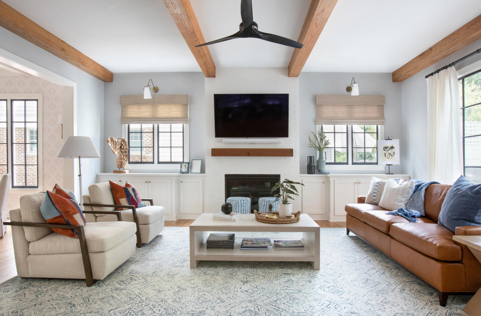 Klassisches Wohnzimmer mit grauer Wandfarbe, hellem Holzboden, Kamin, Kaminumrandung aus Backstein, TV-Wand und braunem Boden in Atlanta