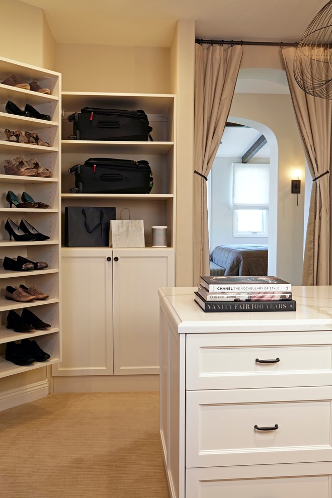 Large mediterranean gender-neutral walk-in wardrobe in Los Angeles with recessed-panel cabinets, white cabinets and carpet.