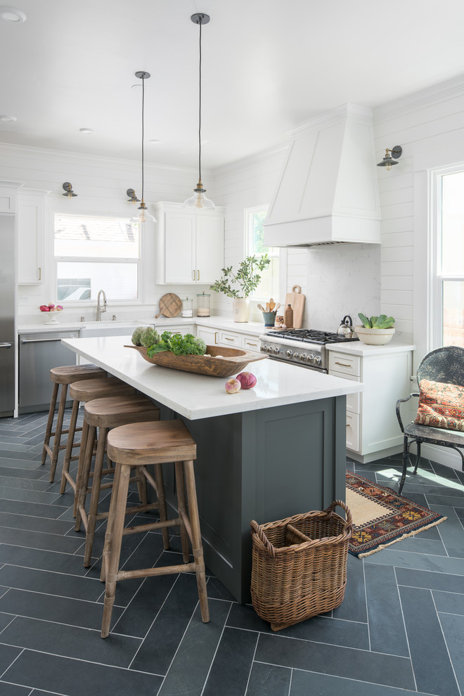 Design ideas for a mid-sized traditional l-shaped kitchen in Sacramento with a farmhouse sink, shaker cabinets, white cabinets, quartzite benchtops, stone slab splashback, stainless steel appliances, slate floors, with island and grey floor.