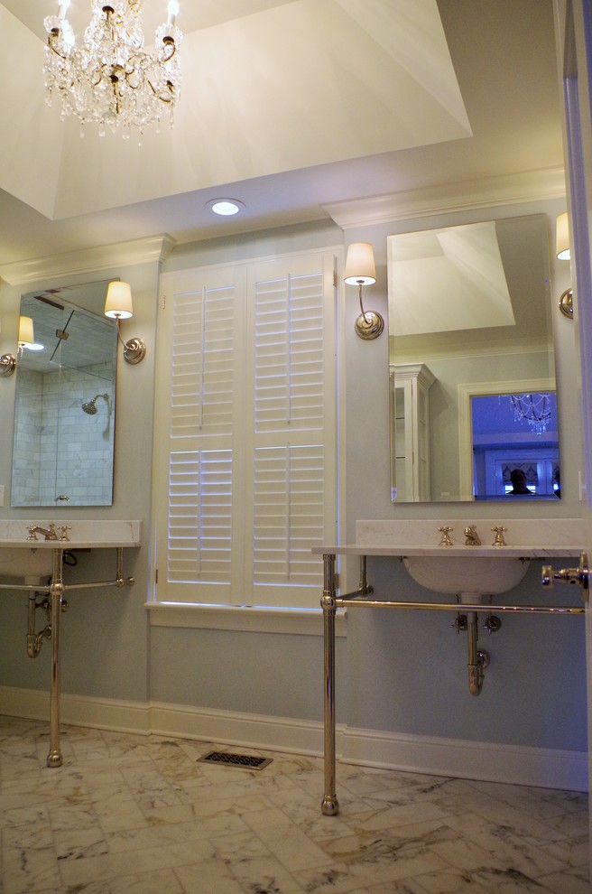 This is an example of a mid-sized traditional master bathroom in St Louis with raised-panel cabinets, medium wood cabinets, a corner shower, grey walls, porcelain floors, an integrated sink, onyx benchtops, multi-coloured floor and a hinged shower door.