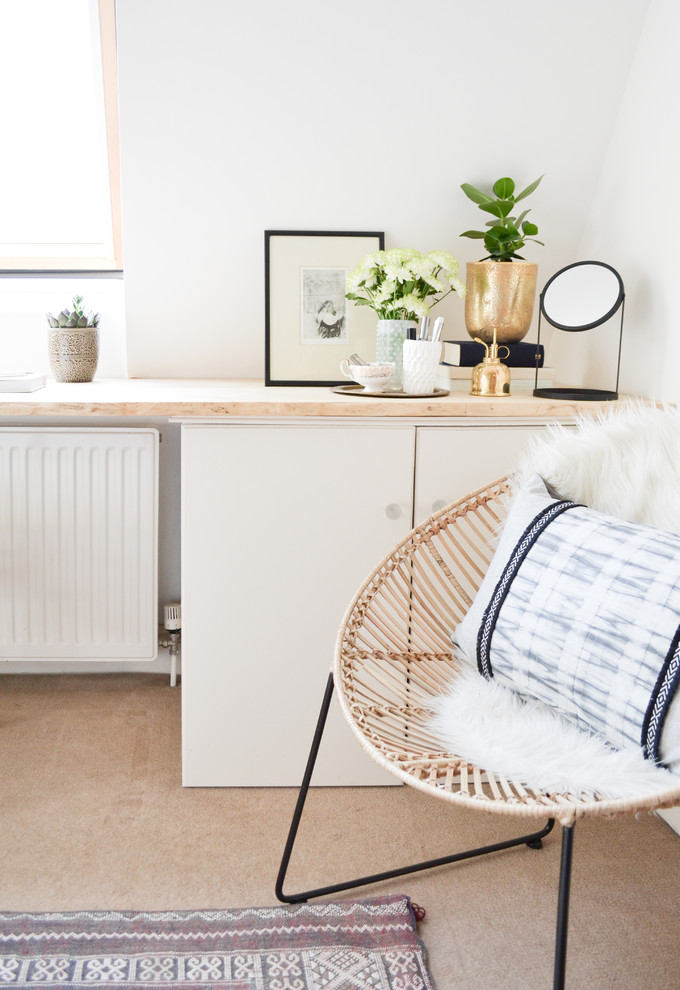 Photo of a mid-sized scandinavian home office in London with white walls, carpet and a built-in desk.