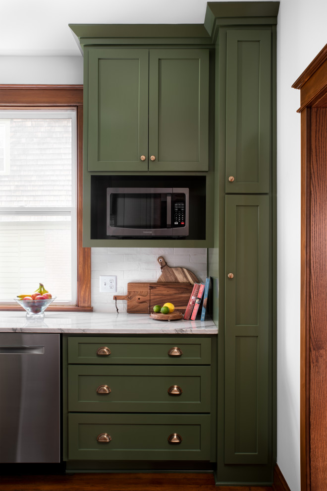 Mid-sized arts and crafts galley medium tone wood floor and brown floor eat-in kitchen photo in Kansas City with a farmhouse sink, shaker cabinets, green cabinets, quartzite countertops, gray backsplash, ceramic backsplash, stainless steel appliances, no island and gray countertops