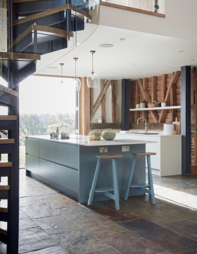 This is an example of a contemporary kitchen in Surrey with flat-panel cabinets, grey cabinets, quartz worktops and an island.