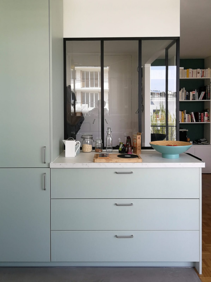 Design ideas for a small contemporary u-shaped open plan kitchen in Paris with an undermount sink, flat-panel cabinets, green cabinets, marble benchtops, grey splashback, black appliances, concrete floors, grey floor and white benchtop.