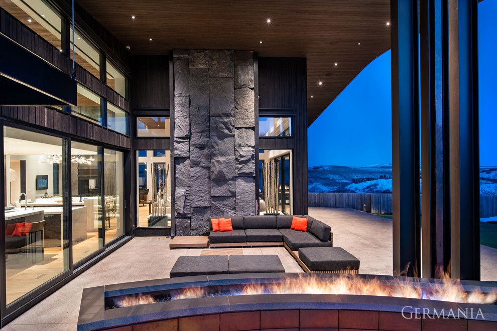 Inspiration for a modern backyard patio in Salt Lake City with a fire feature, concrete slab and a roof extension.