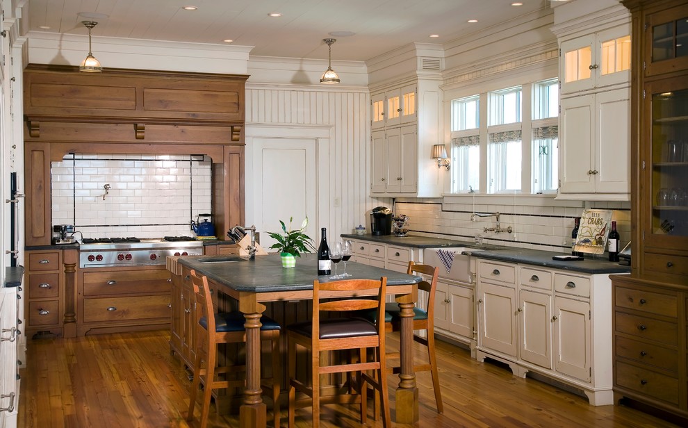 Beach style u-shaped separate kitchen in Charleston with a farmhouse sink, recessed-panel cabinets, white cabinets and white splashback.