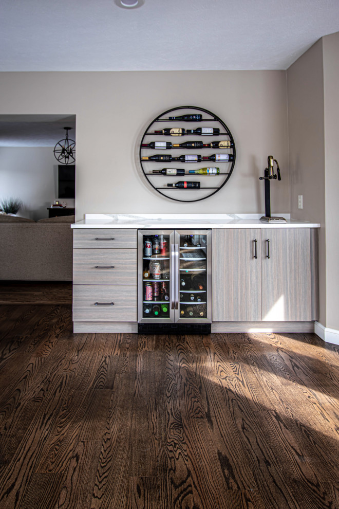 This is an example of a small transitional single-wall home bar in Cleveland with flat-panel cabinets, grey cabinets, quartz benchtops and white benchtop.