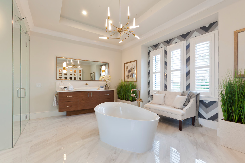 Design ideas for an expansive transitional master bathroom in Tampa with flat-panel cabinets, white cabinets, a freestanding tub, a corner shower, a one-piece toilet, gray tile, subway tile, white walls, porcelain floors, a vessel sink, solid surface benchtops, multi-coloured floor, a hinged shower door and white benchtops.