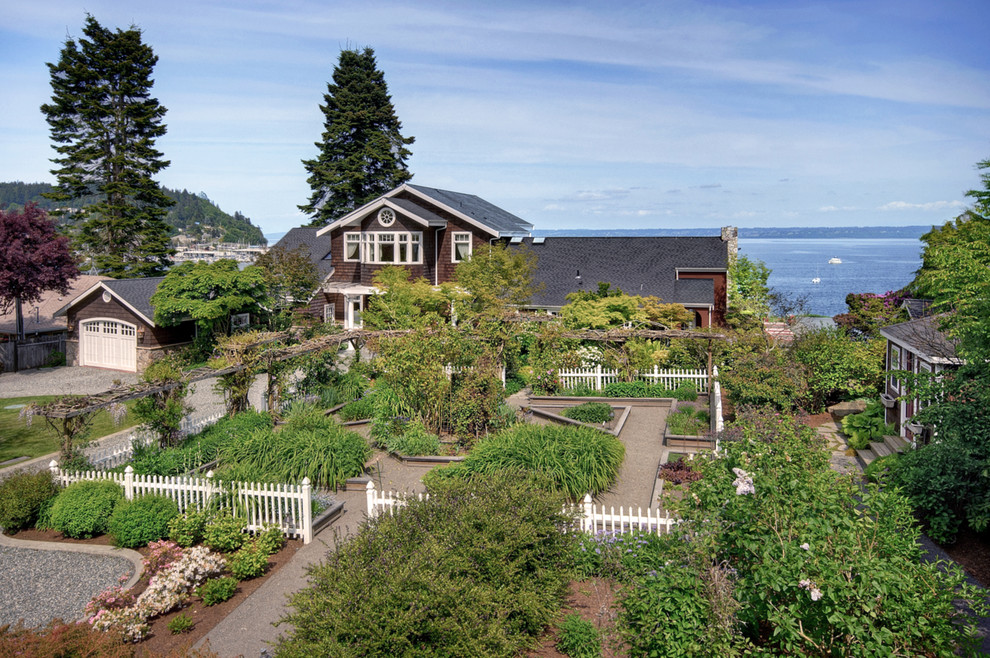 Photo of a large beach style two-storey brown exterior in Seattle with wood siding and a gable roof.