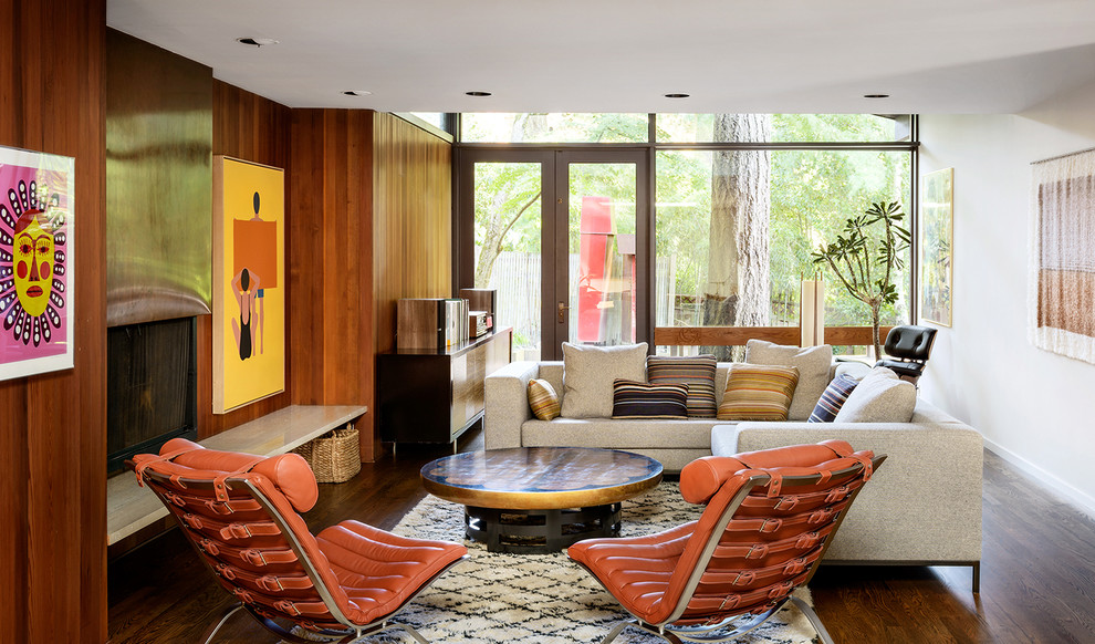 Midcentury family room in Portland with white walls, medium hardwood floors and a standard fireplace.