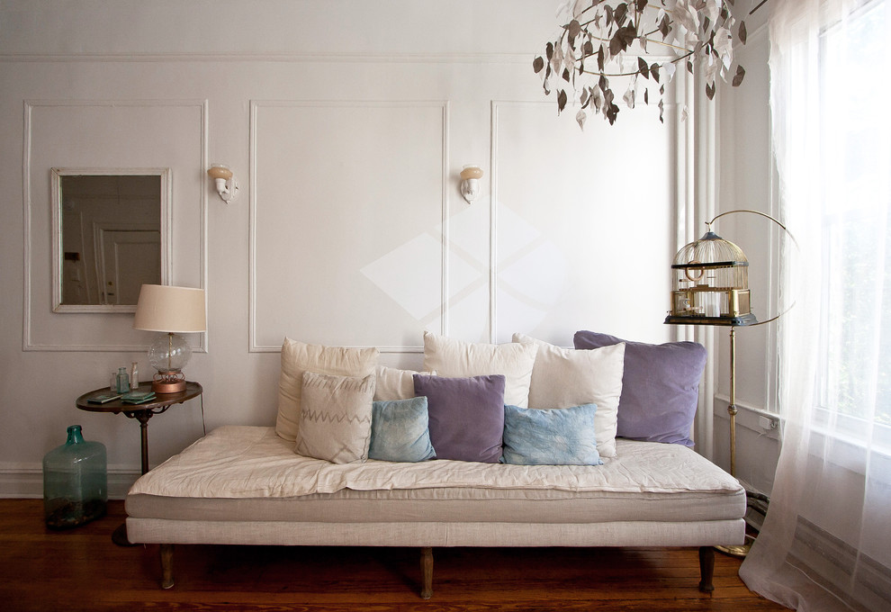 This is an example of an eclectic living room in New York with white walls.