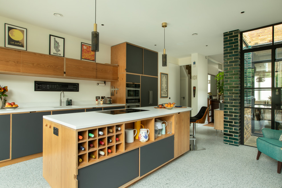 Aménagement d'une grande cuisine ouverte contemporaine avec des portes de placards vertess, un plan de travail en quartz, un sol en terrazzo et un plan de travail blanc.