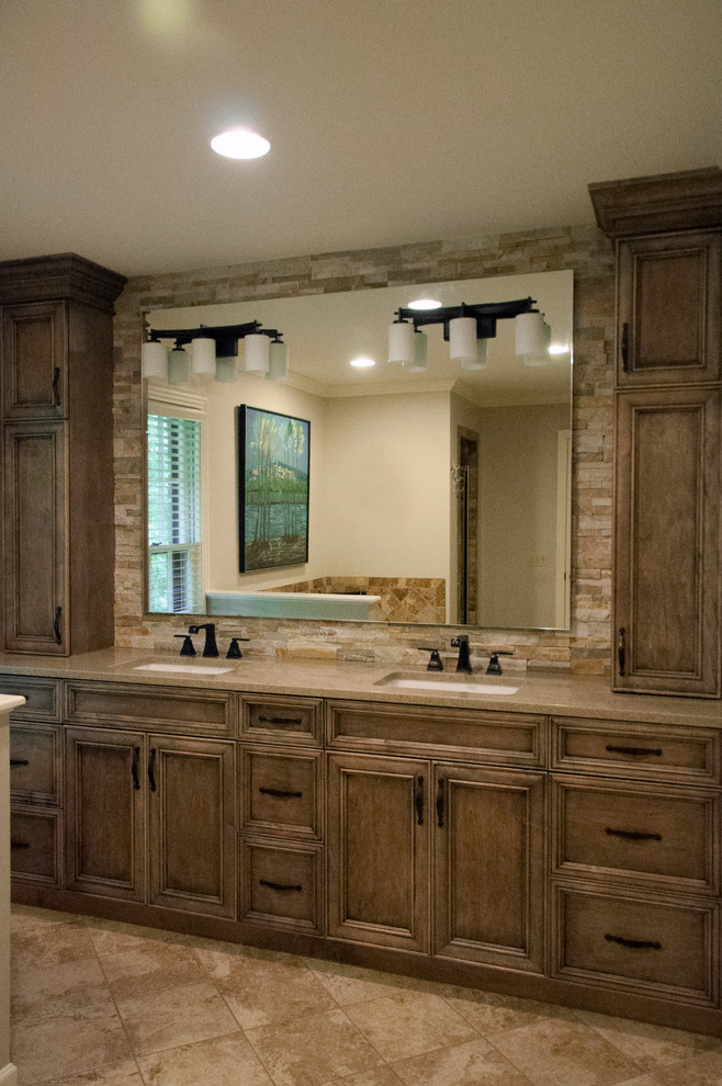 This is an example of a mid-sized country master bathroom in Nashville with medium wood cabinets, engineered quartz benchtops, beige tile, stone tile, travertine floors, an undermount sink, recessed-panel cabinets, beige floor, beige benchtops and beige walls.