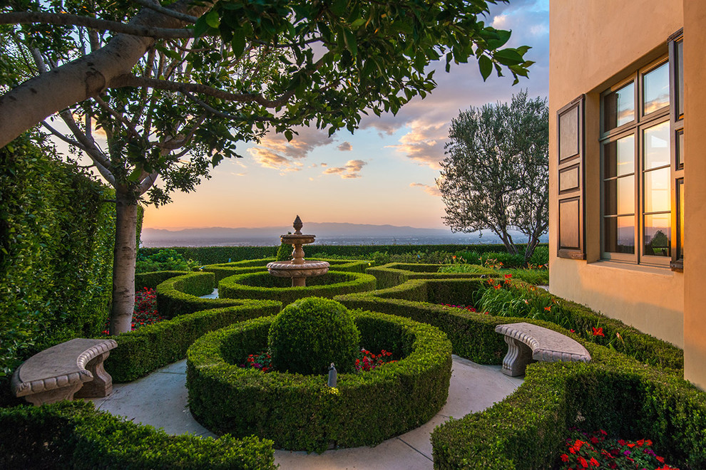 Inspiration for an expansive mediterranean side yard partial sun formal garden in Los Angeles with a water feature and concrete pavers.