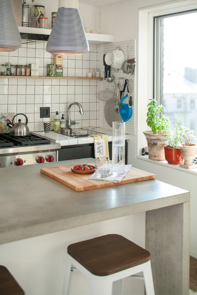 Small contemporary u-shaped kitchen in New York with an integrated sink, open cabinets, white splashback, porcelain splashback, stainless steel appliances and a peninsula.