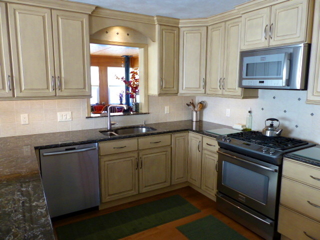 Mid-sized mountain style u-shaped light wood floor eat-in kitchen photo in New York with raised-panel cabinets, beige cabinets, quartz countertops, a peninsula, an undermount sink, beige backsplash, ceramic backsplash and stainless steel appliances