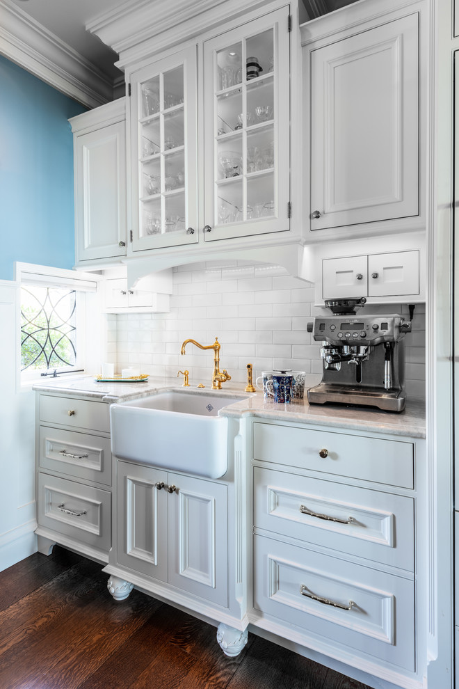 Design ideas for a traditional single-wall wet bar in Seattle with an undermount sink, raised-panel cabinets, white cabinets, white splashback, subway tile splashback and dark hardwood floors.
