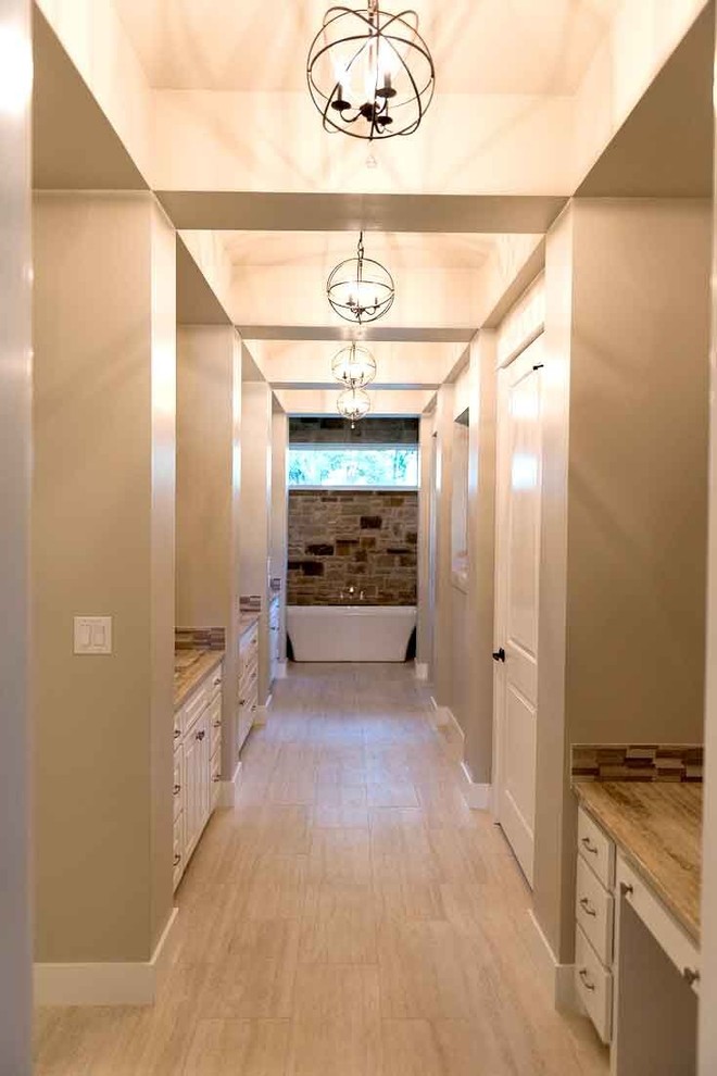 Freestanding bathtub - large transitional master beige tile and stone tile porcelain tile and beige floor freestanding bathtub idea in Austin with shaker cabinets, white cabinets, beige walls and granite countertops