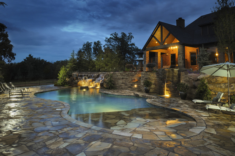 Inspiration for a large mediterranean custom-shaped natural pool in Oklahoma City with natural stone pavers.